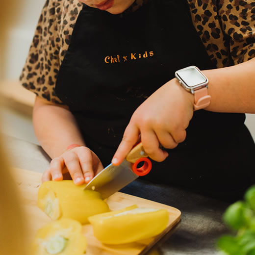 Een kind van groentes aan het snijden is om mee te koken